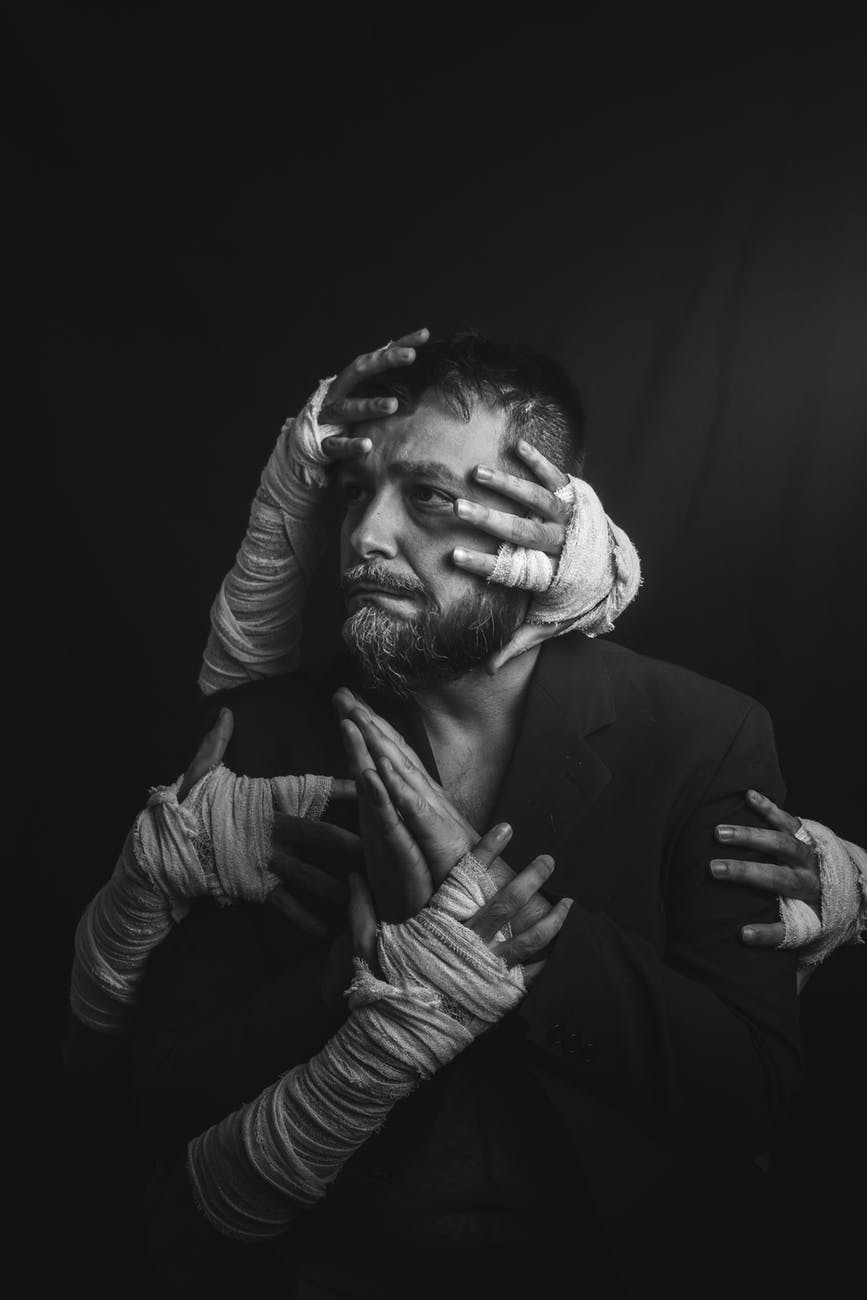 monochrome photo of man with hands all over him